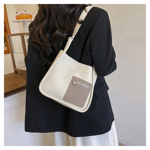 Detail of minimalist lychee pattern shoulder bag in cream and taupe with strap