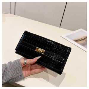 Détail de cuir noir verni à motif crocodile sur sac à main avec fermoir doré rotatif