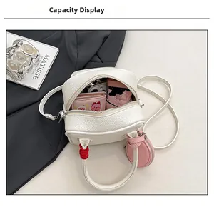 Internal capacity of mini white crossbody bag showing storage for phone and umbrella