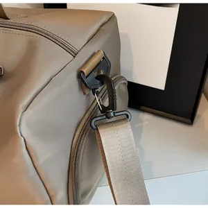 Detail of durable khaki Oxford fabric with reinforced leather edges and matte black hook