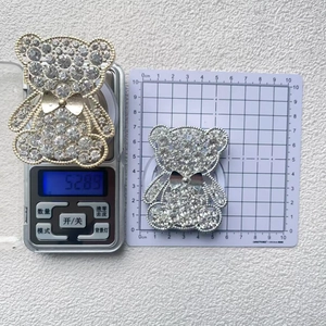 Detail of crystal-encrusted cartoon bear phone grip with gold and silver metallic frames