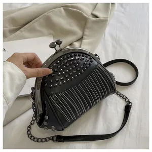 Detailed view of vintage black clutch bag featuring metallic rivets and silver fringes