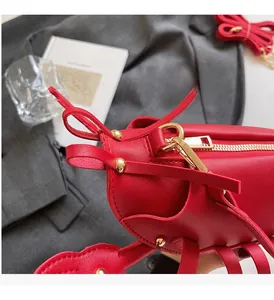 Detail of red lobster-shaped saddle bag with pebble leather and gold hardware accents
