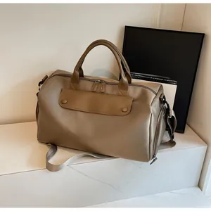 Macro shot of khaki waterproof nylon travel bag with brown leather details and shoulder strap