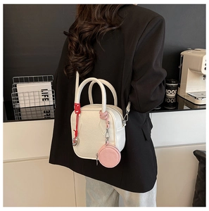 Detail of white lychee pattern leather handbag with pink mini coin purse accessory