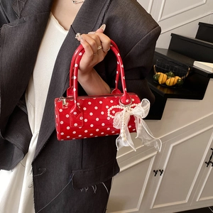 Red polka dot cylinder handbag with white organza bow and pearl charm on 45-degree angle