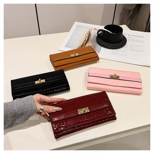 Détail de quatre portefeuilles en cuir effet croco en bordeaux, noir, rose et marron