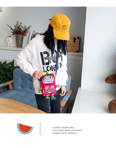 Fille portant un sac à bandoulière robot rose avec détails colorés en pièce claire