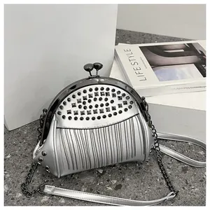 Detail of silver shell bag with black metal kiss lock and tassel rivet decorations