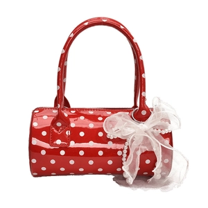 Red patent leather polka dot cylinder handbag with white lace bow and pearl chain