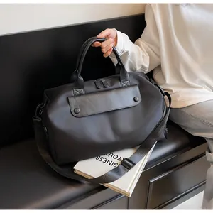 Detail of black oxford fitness bag featuring leather flap pocket and metal zippers