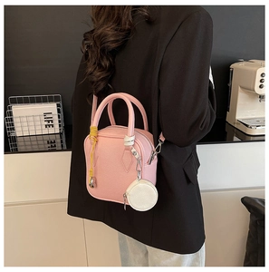 Pink lychee grain leather crossbody box bag featuring a mini white coin purse charm