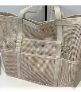 Detail view of breathable cream mesh fabric and reinforced woven handles on large tote bag