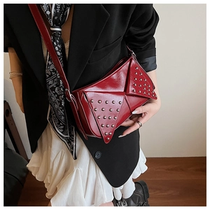 Close-up of burgundy rivet shoulder bag featuring punk style metal studs and flap detail