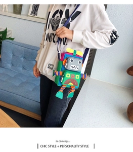 Détail d'un sac bandoulière en forme de robot avec toile multicolore et poches zippées