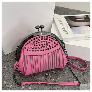 Detail of pink semicircular clutch with metal studs and dense silver chain tassels