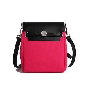 Stylish magenta canvas crossbody bag with black leather flap and silver buckle