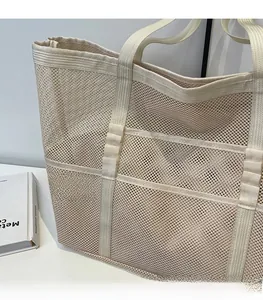 Detail of light beige mesh tote bag showing reinforced woven straps and breathable fabric