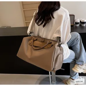 Detailed back view of a large khaki oxford travel bag carried in a modern interior