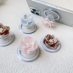 Macro detail of MagSafe phone grip featuring gradient resin floral petals and pearl center