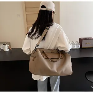 Detail of tan gym bag with adjustable shoulder strap and side zipper pocket