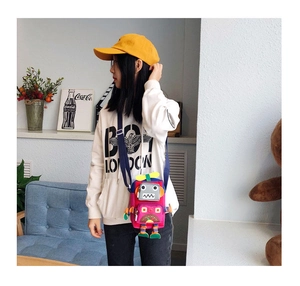 Détail du sac bandoulière robot mignon en magenta avec accents colorés sur modèle