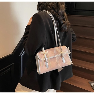 Dettaglio della borsa a tracolla rosa con fiocchi decorativi e bordo argentato