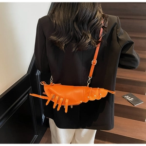 Creative orange lobster shaped crossbody bag shown on model with adjustable strap detail