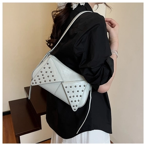 Detail view of white punk chic underarm bag with silver rivet studs and geometric design