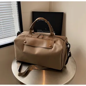 Detailed shot of khaki travel bag with reinforced handles and front flap buckle pockets