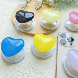 Detailed view of colorful heart-shaped MagSafe phone grips on a wooden display