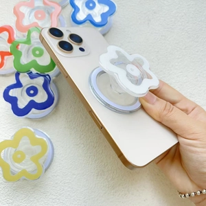 Transparent flower magnetic phone socket holder grip shown being held by a hand on phone