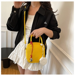 Detail of yellow pebble faux leather mini crossbody bag with cute hanging charms
