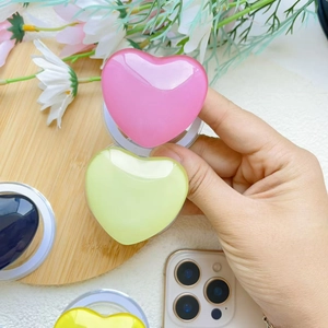 Macro detail of heart-shaped magnetic phone sockets in glossy pink, green and yellow colors