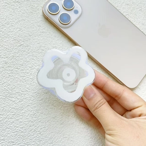 Clear flower pop grip phone socket holder on smartphone with minimalist white petals