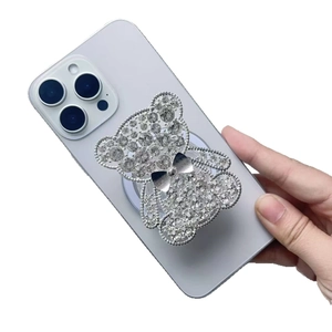 Sparkling rhinestone bear phone socket grip on purple smartphone with silver bow detail
