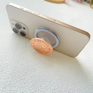 Macro detail of rose gold magnetic phone socket with vintage coin relief carving