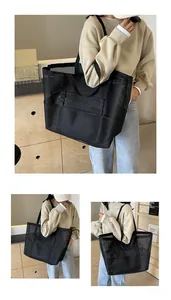 Detail of black mesh tote bag showing spacious compartments and wide shoulder straps