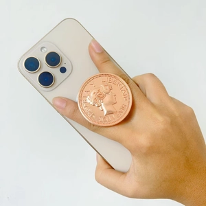 Macro detail of rose gold coin magnetic phone grip with female profile relief