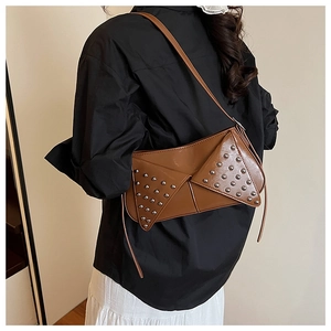 Detail view of a brown punk-style underarm bag with silver rivets and matte finish