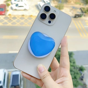 Close-up of a glossy blue heart-shaped MagSafe phone grip holder held in hand