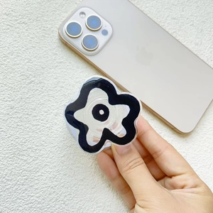 Close-up of a floral phone grip with black and white wavy edges on a smartphone