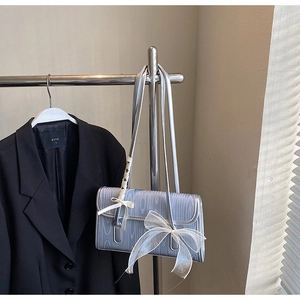 Dettaglio della borsa quadrata azzurra con fiocchi decorativi in organza bianca