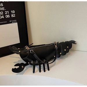 Detail of creative black lobster shaped shoulder bag with golden rivet decorations