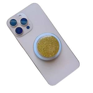 Magnetic glitter phone socket grip in gold sparkles on a white smartphone back