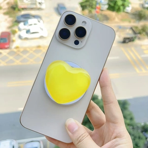 Macro detail of a yellow heart magnetic MagSafe phone grip with jelly texture