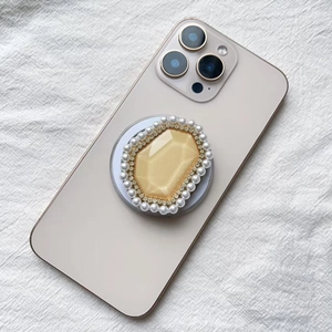 Close-up of luxury Magsafe phone socket with pearl rim and gold diamond crystal gem