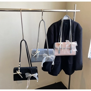 Dettaglio di piccole borse a tracolla in nero blu e rosa con fiocchi in tulle