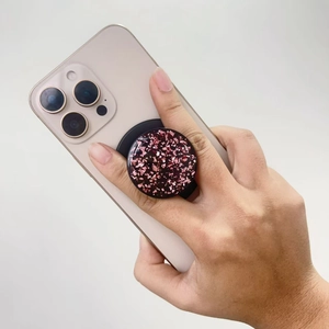 Pink gold foil glitter phone grip socket mounted on a light smartphone held by hand