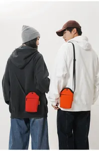 Detail of red and orange canvas mini crossbody phone bags with adjustable straps